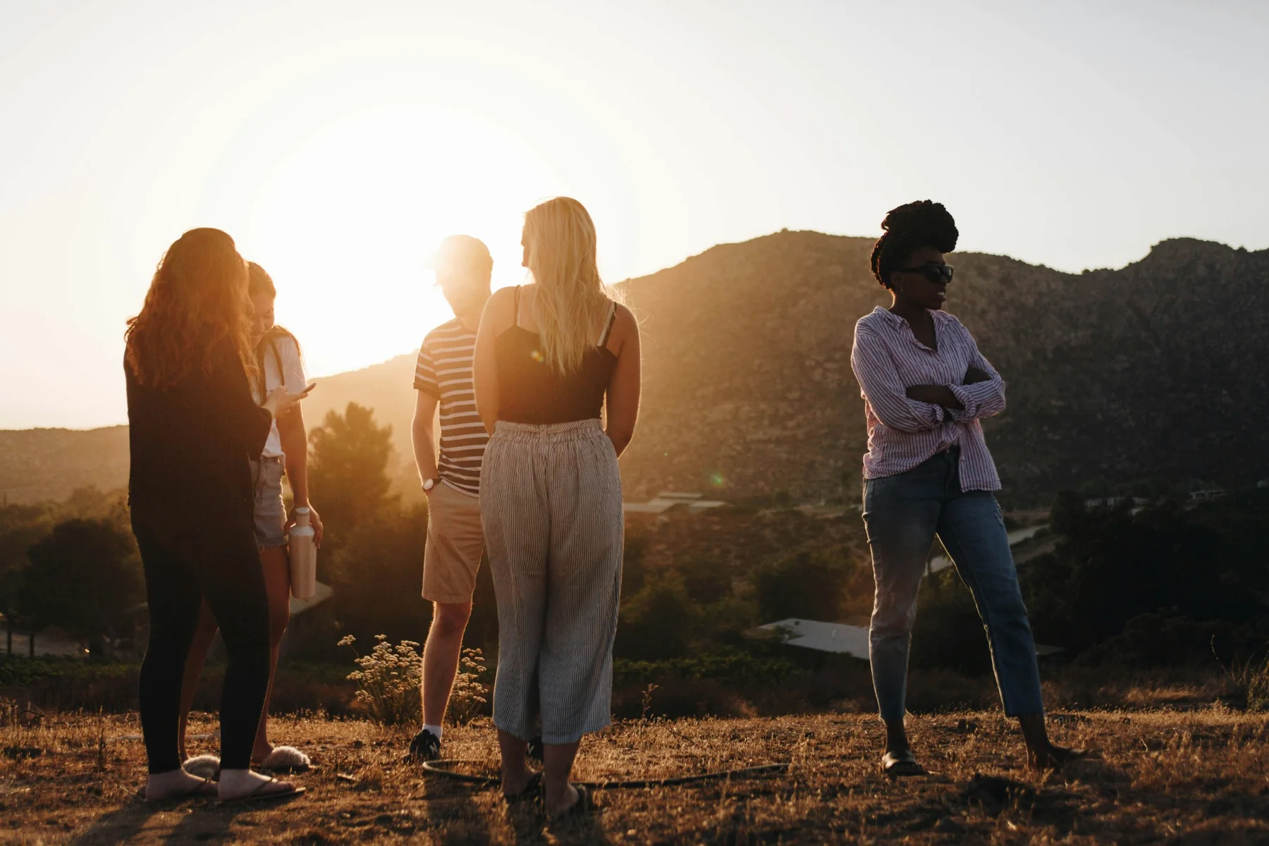 Small group gathered outdoors at sunset